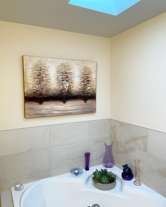 Benjamin Moore Maritime White in a bathroom with gray tile and a painting of three trees on the wall