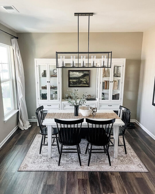 Sherwin Williams Jogging Path on the walls in a dining room with a white wall unit behind the white table and black chairs.