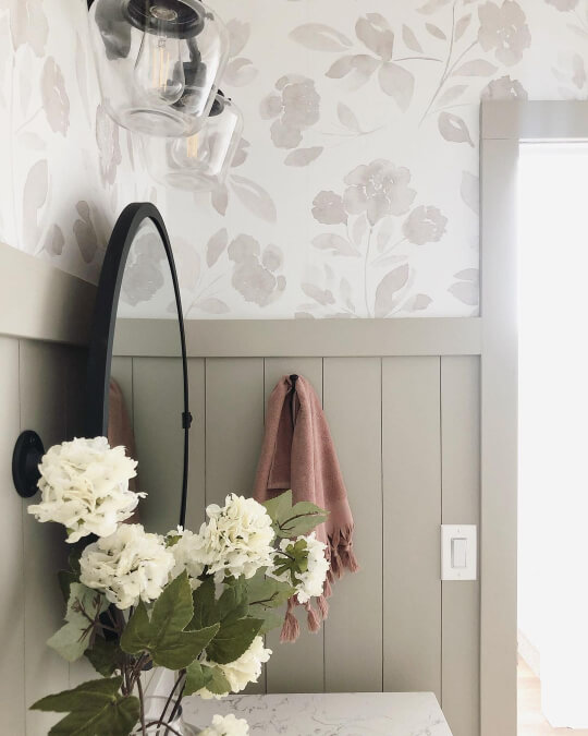 Jogging path shiplap on the lower half of the wall with white and gray floral wallpaper on the top half of the wall.