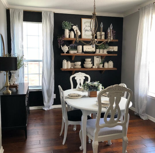 Behr Cracked Pepper on an accent wall in a dining room with white curtains around tall windows and a white wood table and chairs