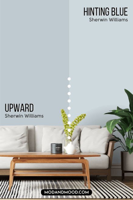 Sherwin Williams Upward on half of a wall and Hinting Blue on the other half behind a white sofa with a wood frame.