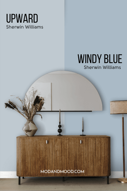 Sherwin Williams Upward on half of a wall and darker shade Windy Blue on the other half behind a white sofa with a wood frame.