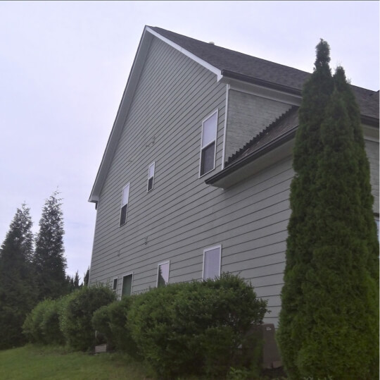 Side of a two storey house with Benjamin Moore Fieldstone dupe Escape Gray on the siding.