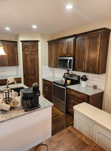 Sherwin Williams Softer Tan on walls in a kitchen with dark wood cabinets and pantry door.