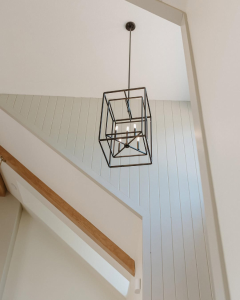 Westhighland White walls with accessible beige trim and accent wall in a foyer with a box chandelier.