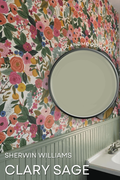 Swatch of Sherwin Williams Clary Sage on a paint lid over a background photo of the color on beadboard and trim in a bathroom with floral wallpaper on the top part of the wall.