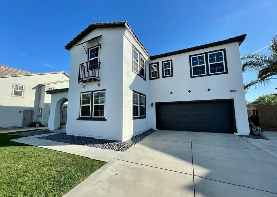 Sherwin Williams Extra White on a stucco exterior with Urbane Bronze on a garage door.