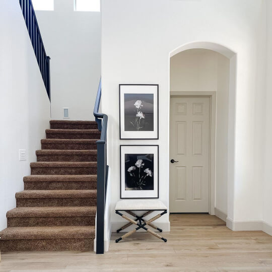 Behr Swiss Coffee walls with Sherwin Williams Accessible Beige on the trim and doors in an area tucked beside a large staircase.