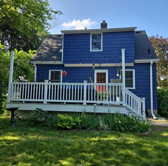 A cute two storey cottage exterior painted in the blue of Sherwin Williams Indigo Batik