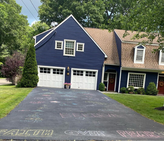 Benjamn Moore Deep Royal on a two storey farmhouse with a brown roof at the end of a long driveway.