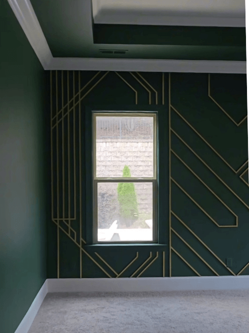Sherwin Williams on all the walls in a living room with white trim and a metallic gold geometric design on the wall.