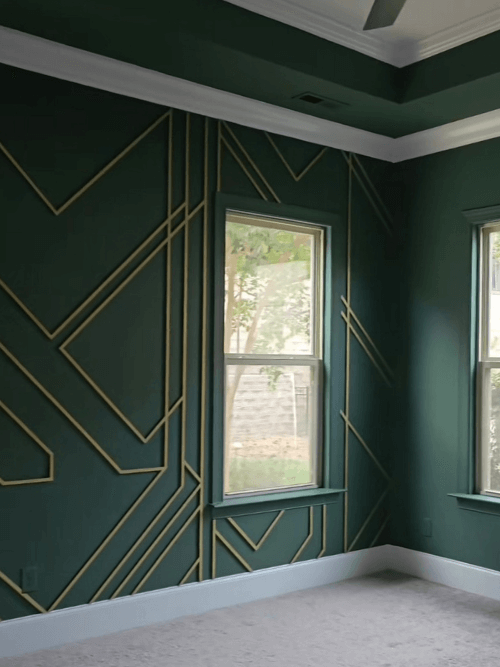 Sherwin Williams on all the walls in a living room with white trim and a metallic gold geometric design on the wall.