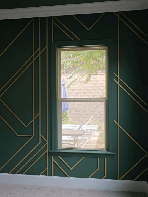 Sherwin Williams on all the walls in a living room with white trim and a metallic gold geometric design on the wall.
