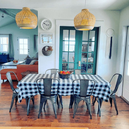 Sherwin Williams Rock Garden on home office french doors off of a dining room with Alabaster walls and Pure White trim. A gingham tablecloth is on the table surrounded by matching black metal chairs. Two rattan look pendants hang from the ceiling.