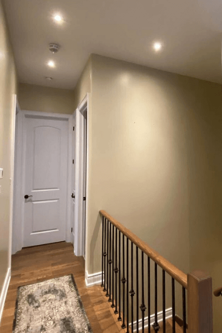 Sherwin Williams Universal Khaki color on walls in a stairwell with white doors and trim.