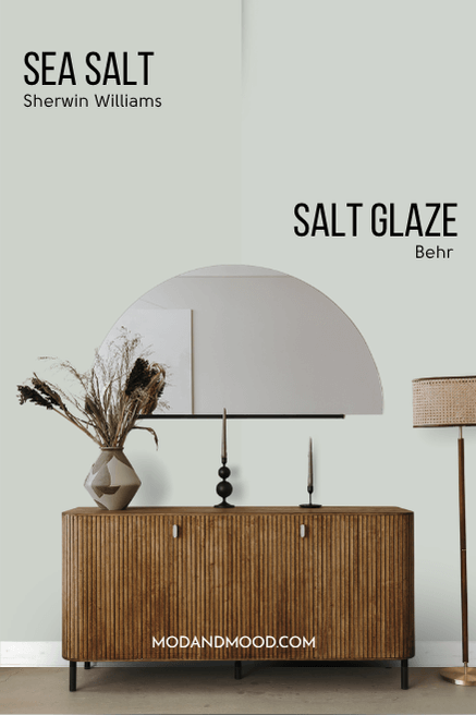 Behr Salt Glaze on half of a wall and Sherwin Williams Sea Salt on the other half behind a hall table with a half circle mirror.