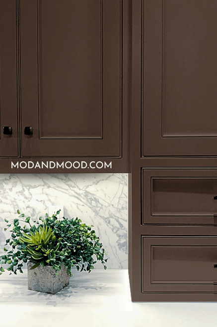 Benjamin Moore French Press on kitchen cabinets with black hardware and marble backsplash and countertop.