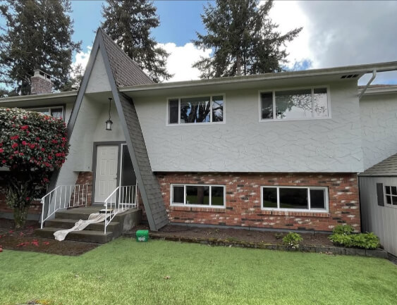 Benjamin Moore Gray Owl on a stucco Exterior with Amherst Gray Trim where it looks like a light warm gray.