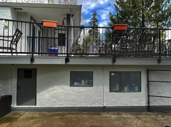 Benjamin Moore Gray Owl on a stucco Exterior with Amherst Gray Trim where it looks like a light greige in the sun.