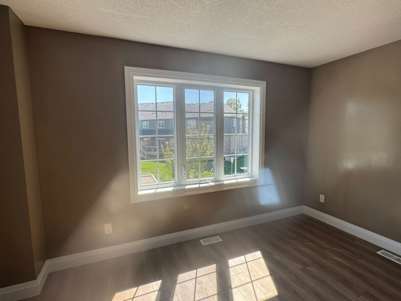 Benjamin Moore Weimaraner on walls with wood flooring and a large window, where the color looks more beige.