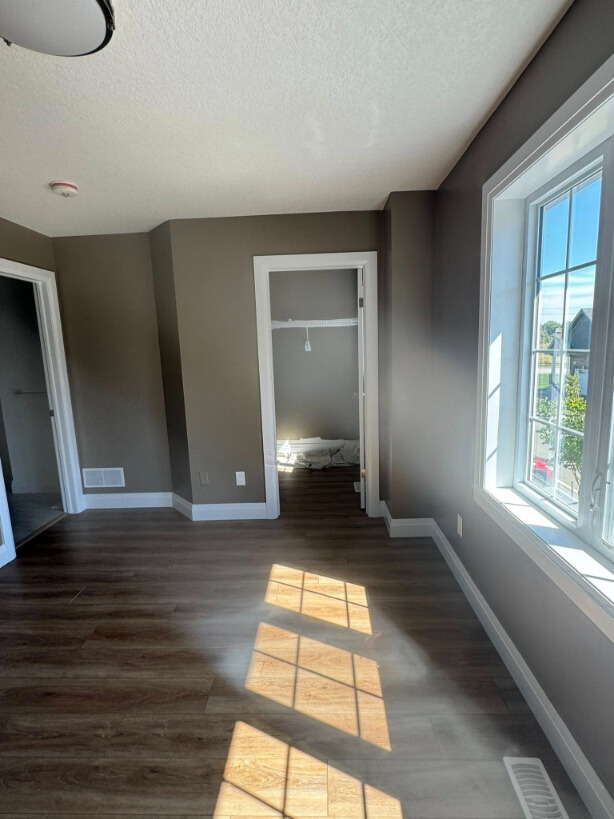 Benjamin Moore Weimaraner on walls with wood flooring and a large window, where the color looks more greige.