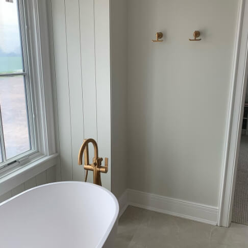 Benjamin Moore Gray Owl on walls in a bathroom with a white tub