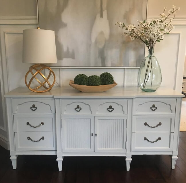 Benjamin moore gray owl on a dresser in darker artificial  lighting against a similar light gray wall