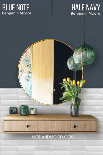 Hale Navy on half of a wall and Blue Note on the other half behind a a round mirror above a floating vanity and white tiled wall.