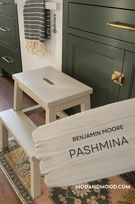 Benjamin Moore Pashmina on a stool in front of green kitchen cabinets