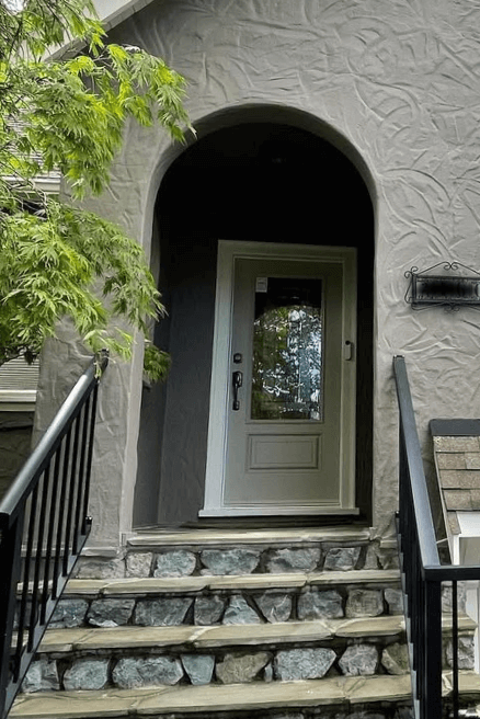 Benjamin Moore Pashmina on a front door with Benjamin Moore Iron Gate on the stucco exterior. Pashmina looks more green.