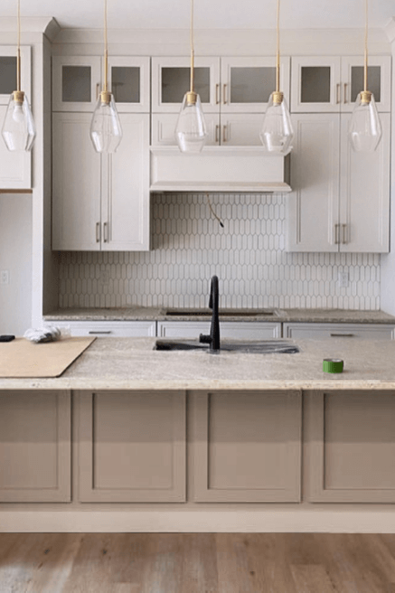 a two toned kitchen with off white wall cabinets and an island in Benjamin Moore Pashmina