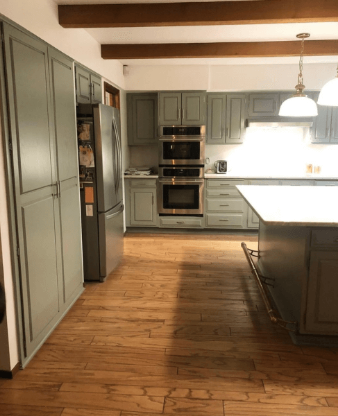 Sherwin Williams Evergreen Fog on perimeter kitchen cabinets in a very large kitchen with a dark wood island
