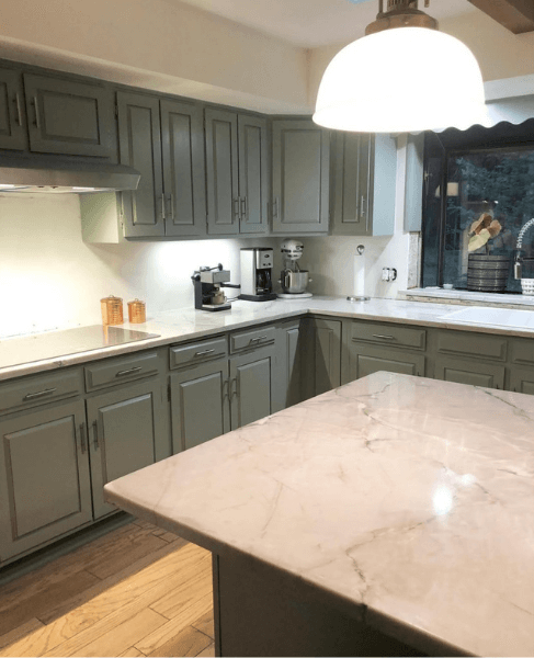 Sherwin Williams Evergreen Fog where it looks cooler on all of the cabinets in a large kitchen.