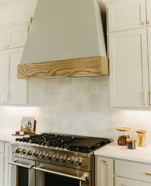 Sherwin Williams Evergreen Fog on a custom hood fan with Gossamer Veil cabinets.