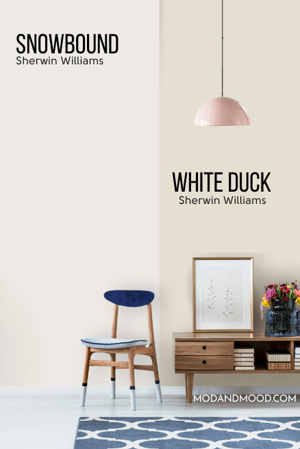 Sherwin Williams Snowbound on half of a wall and white duck on the other half behind a blue and wood chair and a low wood media table.