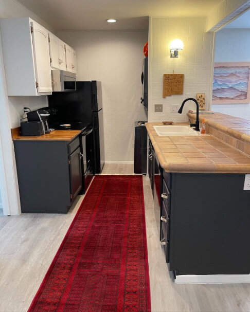 Sherwin Williams Iron Ore on lower cabinets and Drift of Mist on uppers in a refurbished kitchen with butcher block countertops