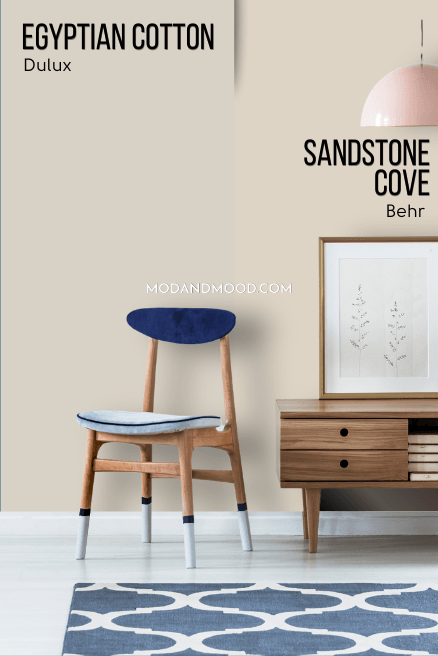 Behr dupe Sandstone Cove on half of a wall and Dulux egyptian cotton on the other half behind a wood console table and a chair with a blue seat cushion.