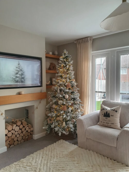 Dulux Egyptian Cotton on walls in a living room decorated for Christmas with a tree and logs in a fireplace.