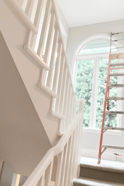 Benjamin Moore Edgecomb Gray looks white in a stairwell with the whiter trim of Benjamin Moore Simply White.