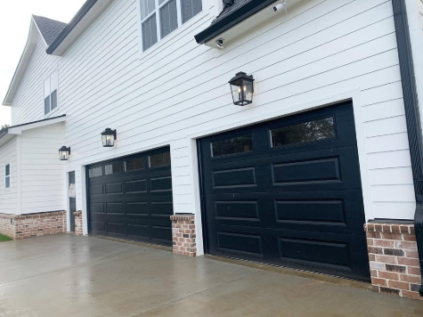 Alabaster looking true white on an overcast day with black garage doors.