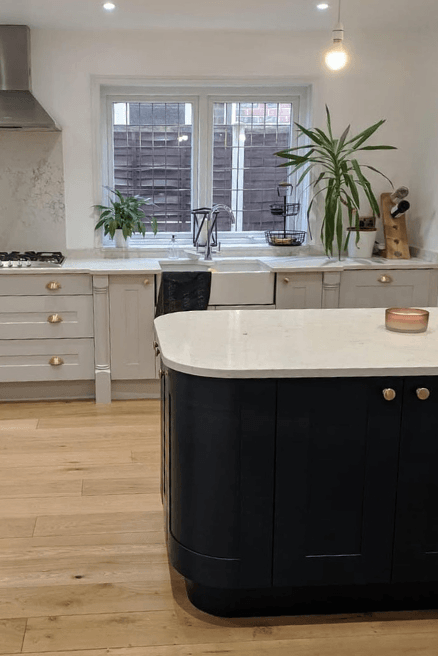 Farrow and Ball Hague Blue looks nearly black on an island with gray perimeter cabinets.
