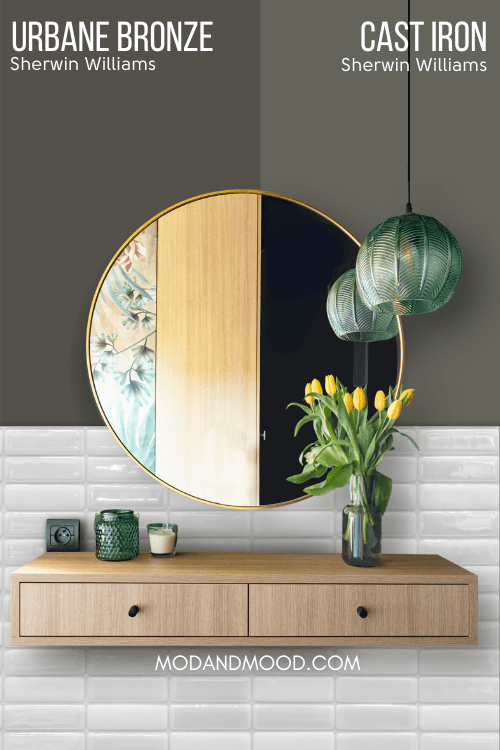 Sherwin Williams Cast Iron on half of a wall and Sherwin Williams Urbane Bronze on the other half behind a round gold mirror and wood vanity