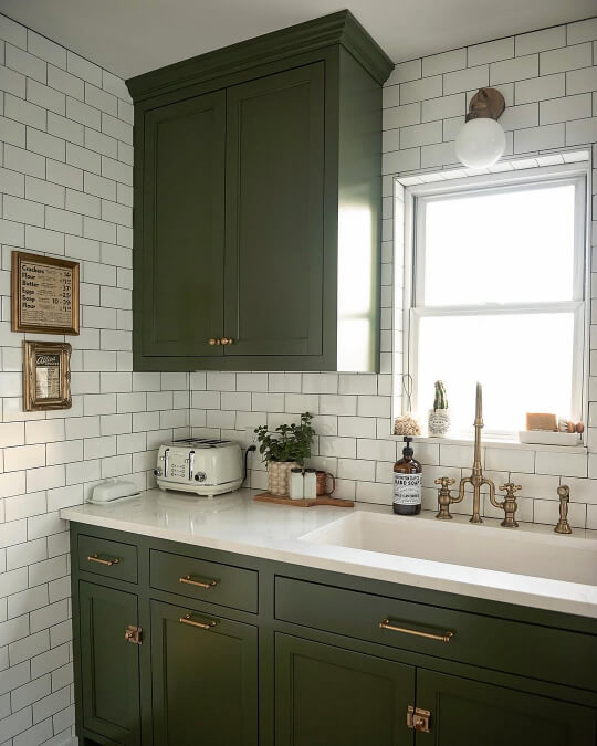 Sherwin Williams Rookwood Dark green on kitchen cabinets with white subway tile and cream countertops