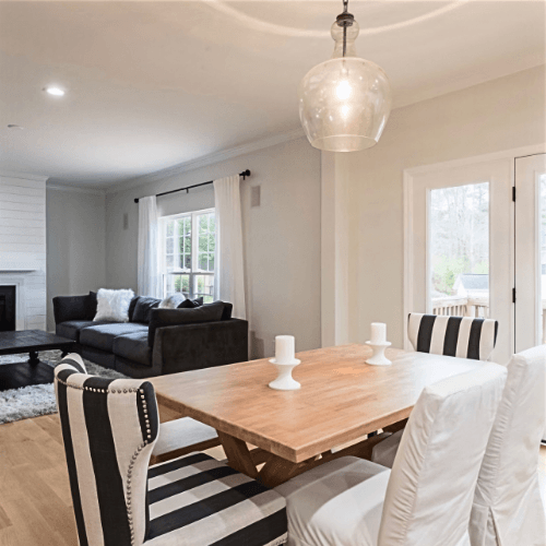Sherwin Williams Spare White where it looks creamy and a little green in the foreground dining room and silver gray in the living room background.