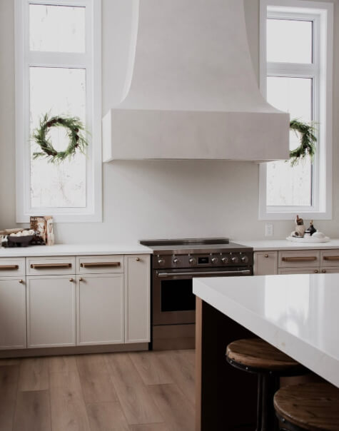 Benjamin Moore Wind's Breath on lower cabinets with a smooth plaster range hood.