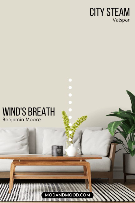 Benjamin Moore Wind's Breath on half of a wall and Valspar dupe City Steam on the other half behind a white sofa with a wood frame.