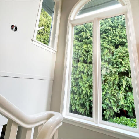 Benjamin Moore edgecomg Gray aka baby fawn on walls with simply white trim in a stairwell.