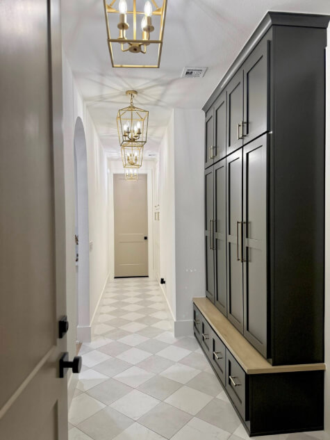 Benjamin Moore Dragon's Breath in a long white hallway with Dragon's Breath cabinets on the right side and an Indian River door at the end of the hallway.