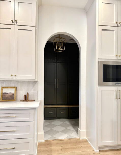 Dragon's Breath on tall cabinets and a bench peaking through an arched door between Pale Oak kitchen cabinets.