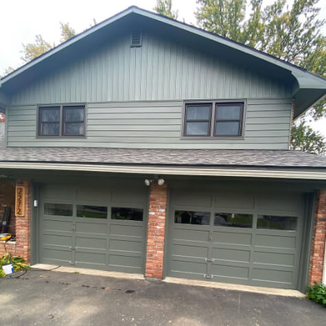 Sherwin Williams Cast Iron or lookalike on siding and garage doors on a two storey brick house.